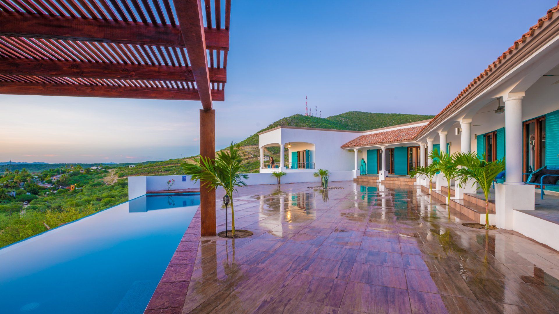 A large white house with a swimming pool in front of it.