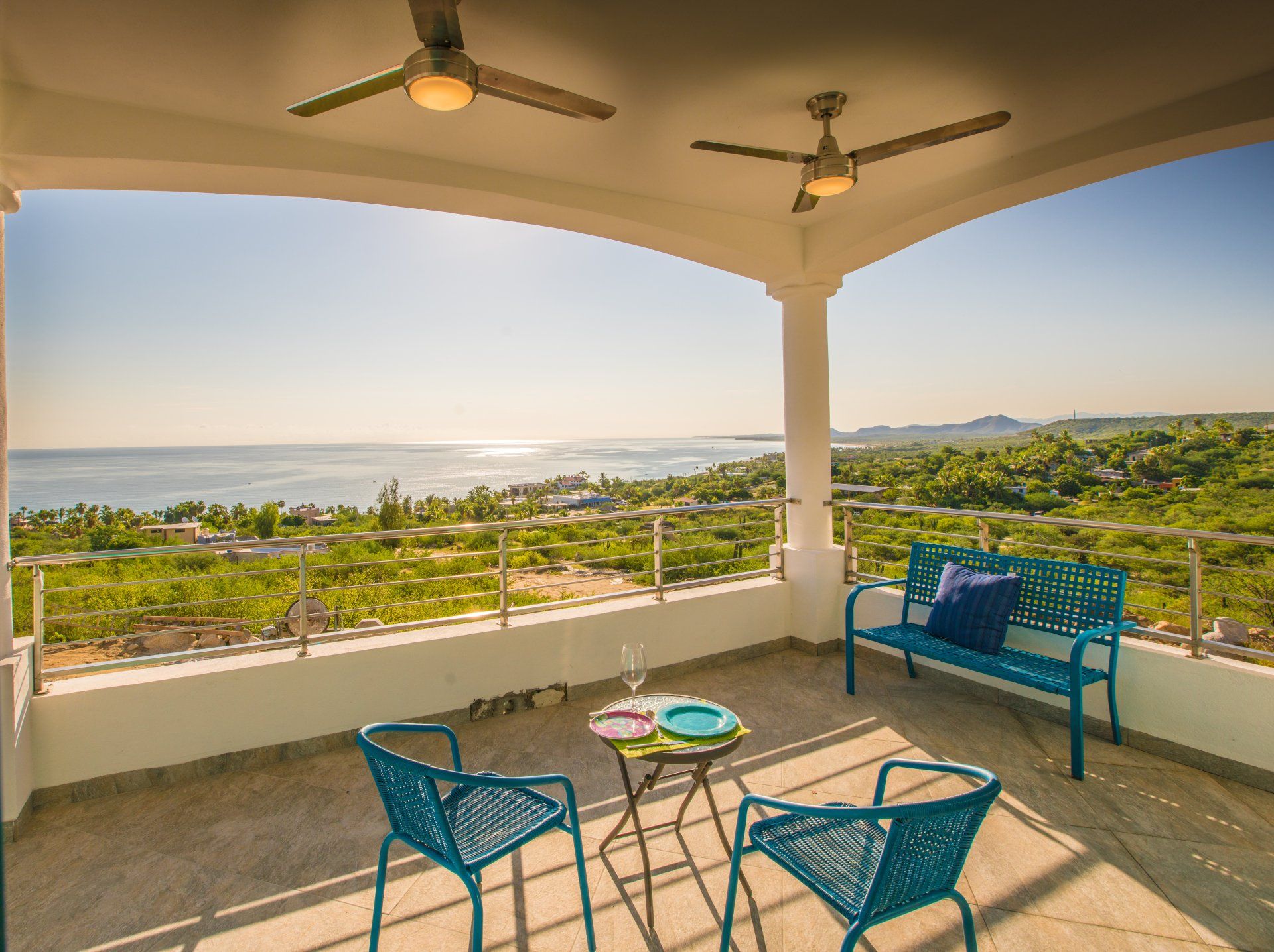 A balcony with a table and chairs overlooking the ocean
