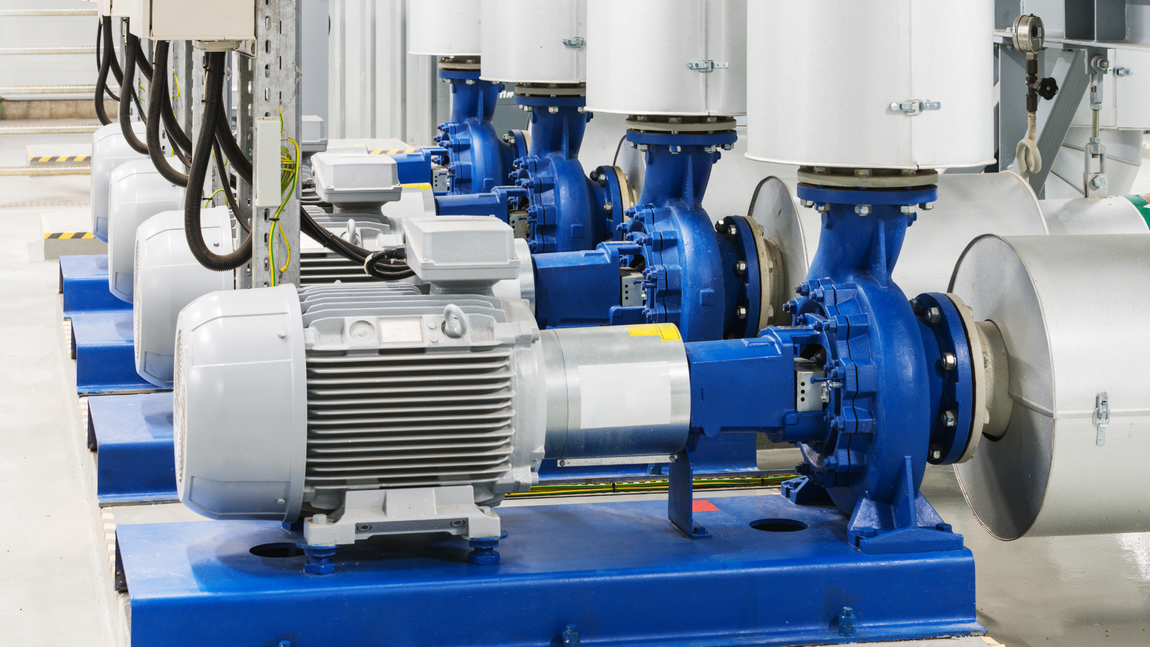 A row of water pumps are lined up in a factory.