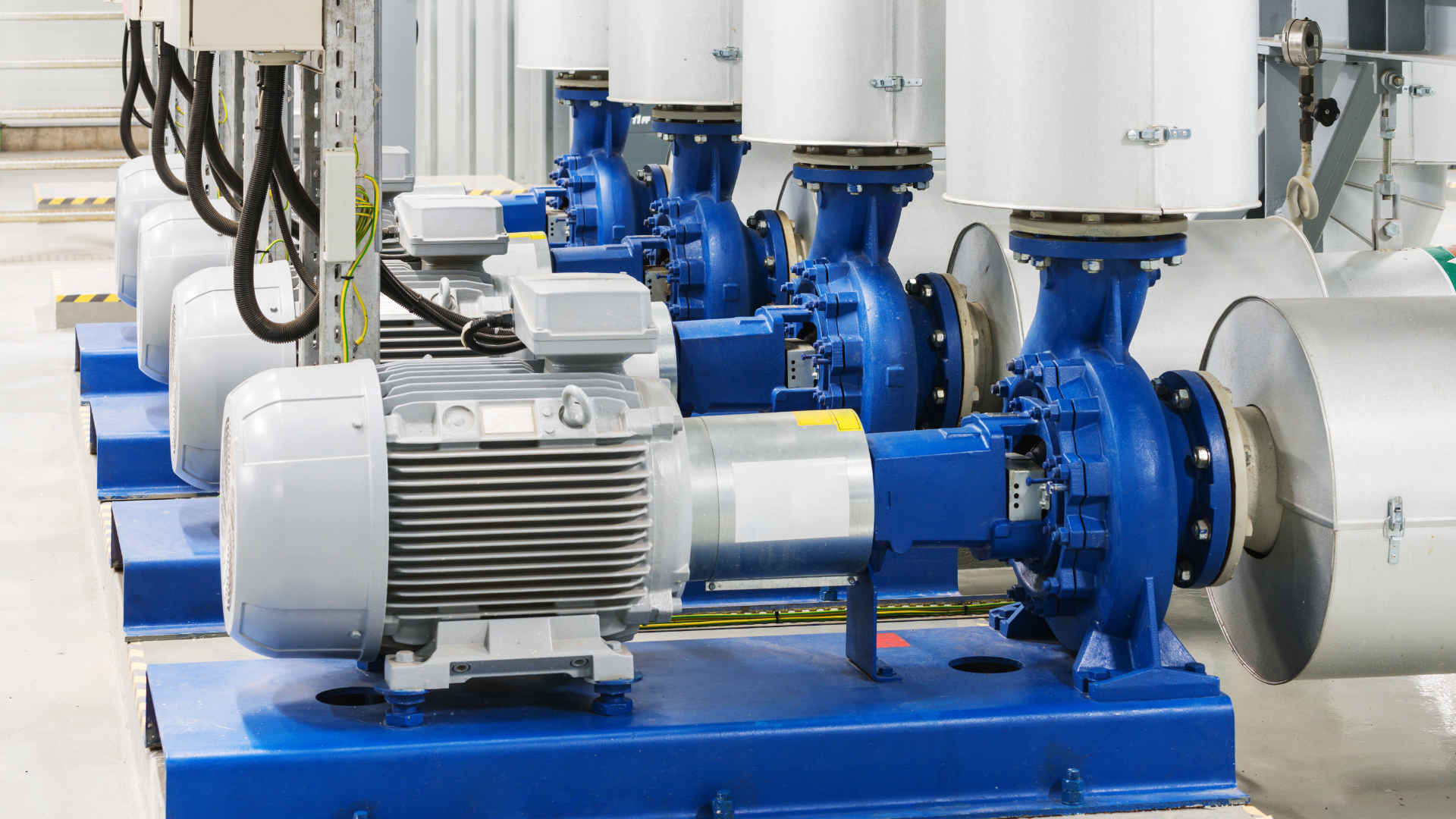 A row of water pumps are lined up in a factory.