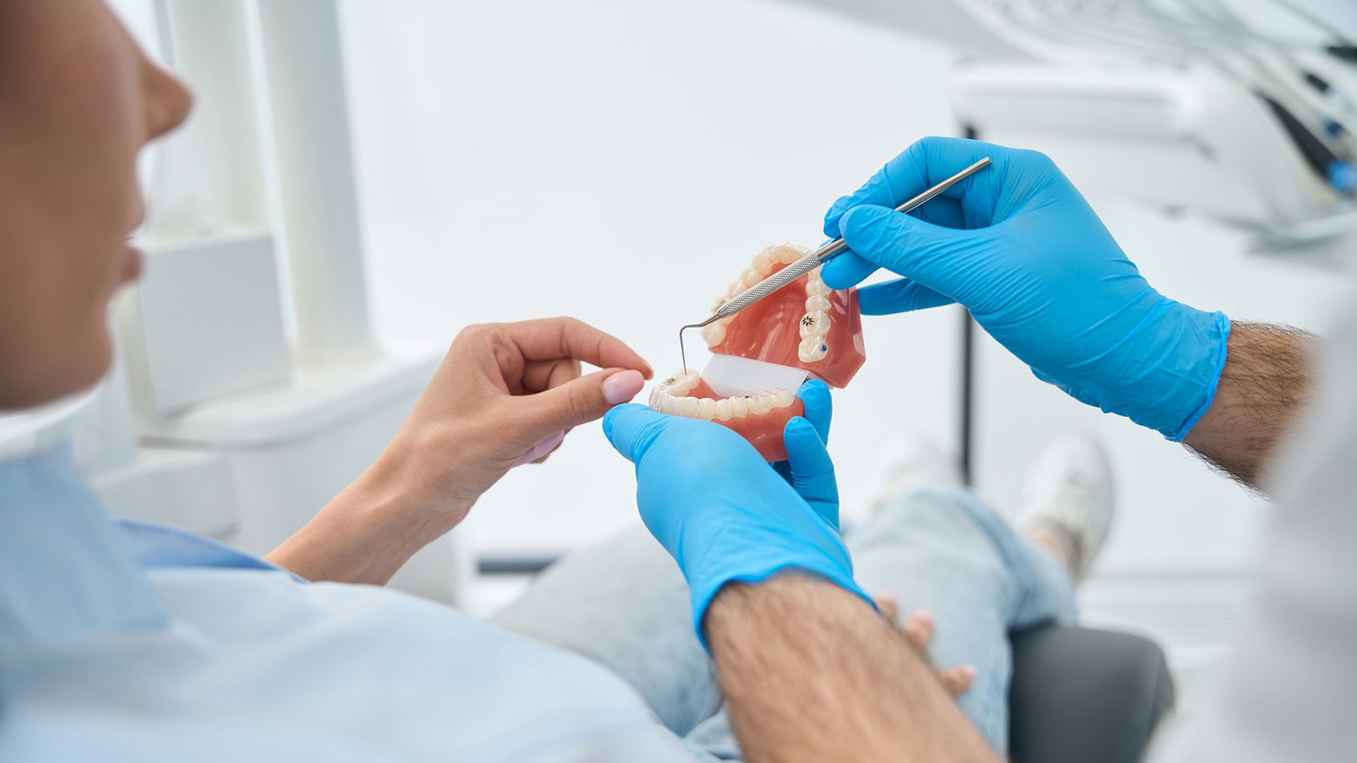 Dentist Showing a Patient a Model of Teeth