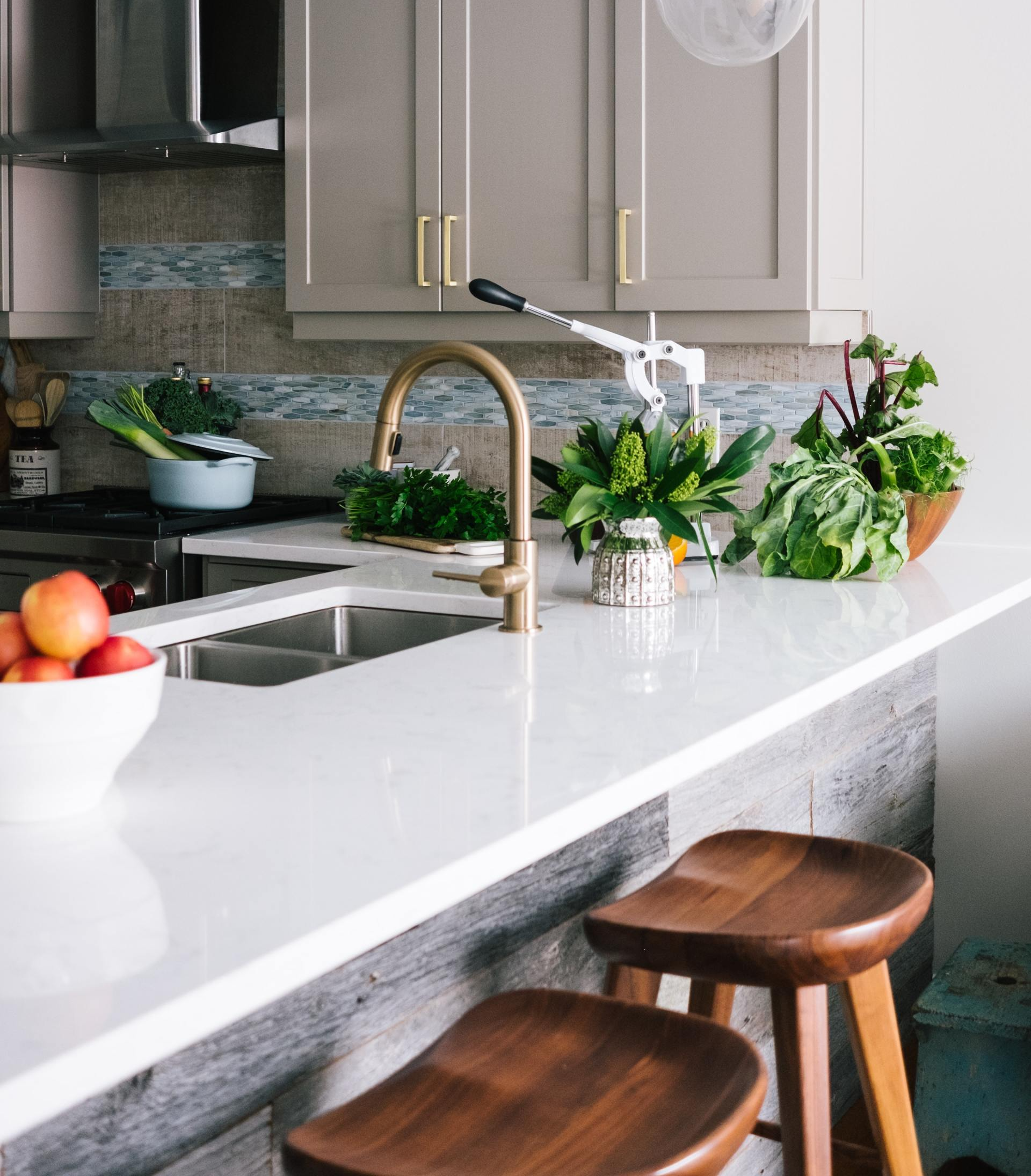 A kitchen counter with a sink and a bowl of fruit on it