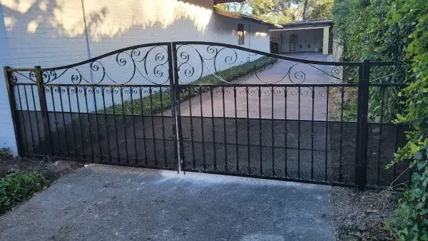 A wrought iron gate is sitting in front of a house.