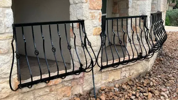 There is a wrought iron railing on the side of a building.