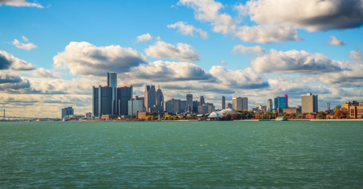Detroit city skyline across the river under blue skies — home to Vibe 35 Michigan, a 35-minute high-energy fitness program for total body transformation.