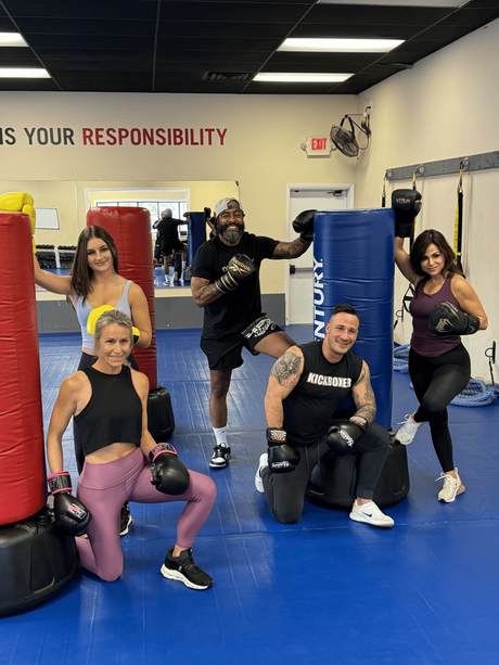 A group of people are stretching on a red mat