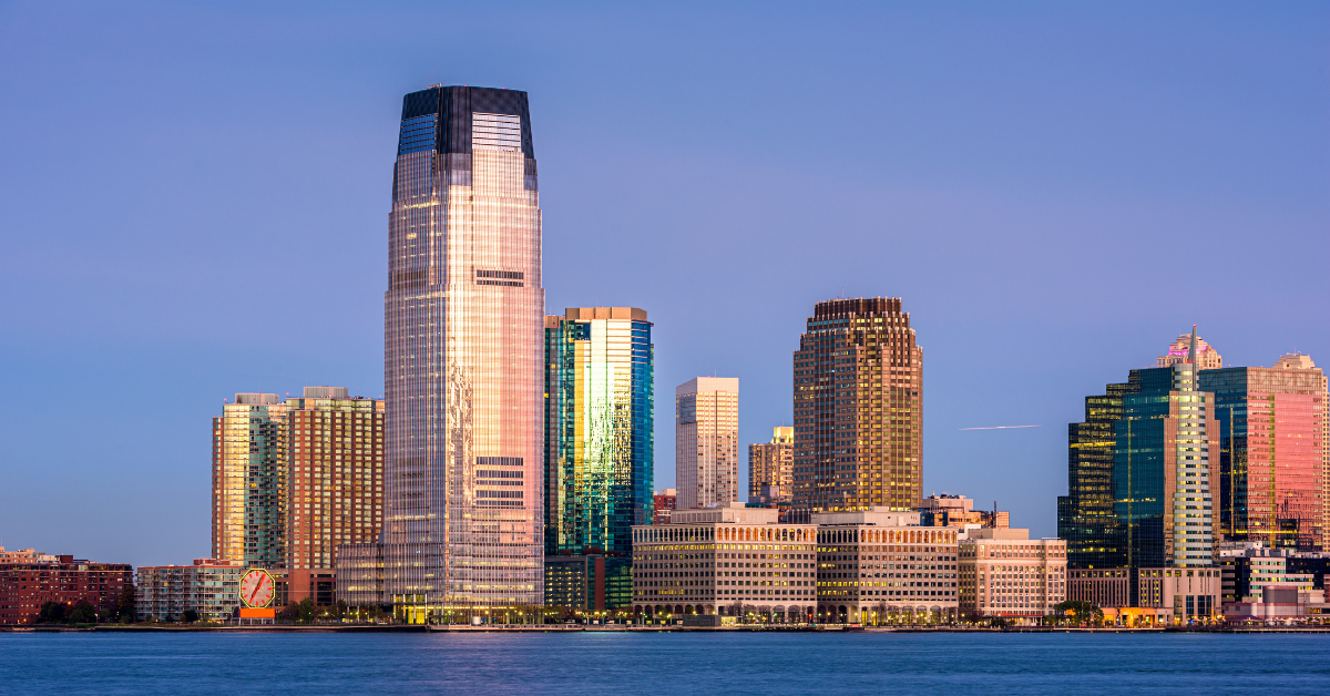 Exchange Place skyline in Jersey City, New Jersey, USA, featuring modern high-rise buildings and waterfront view at sunset.