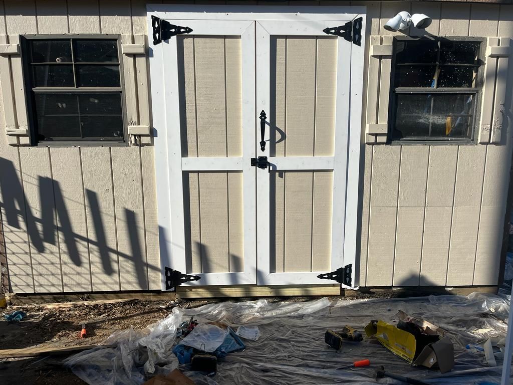 A shed with a white door and two windows