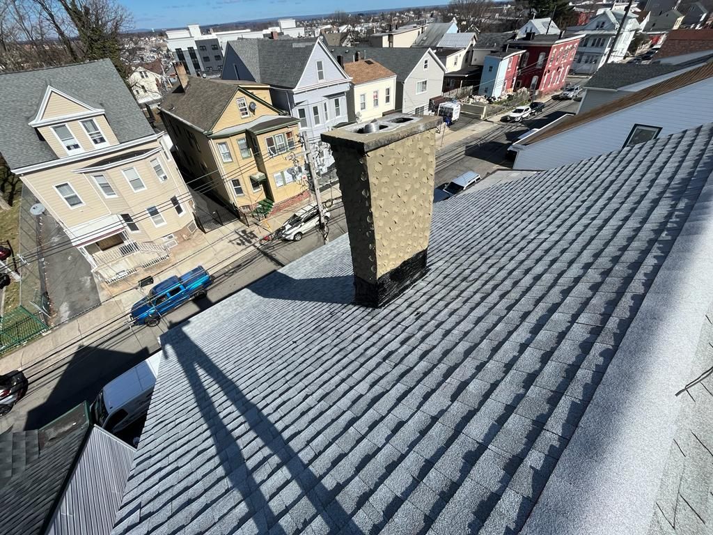 A chimney on the roof of a building in a city.