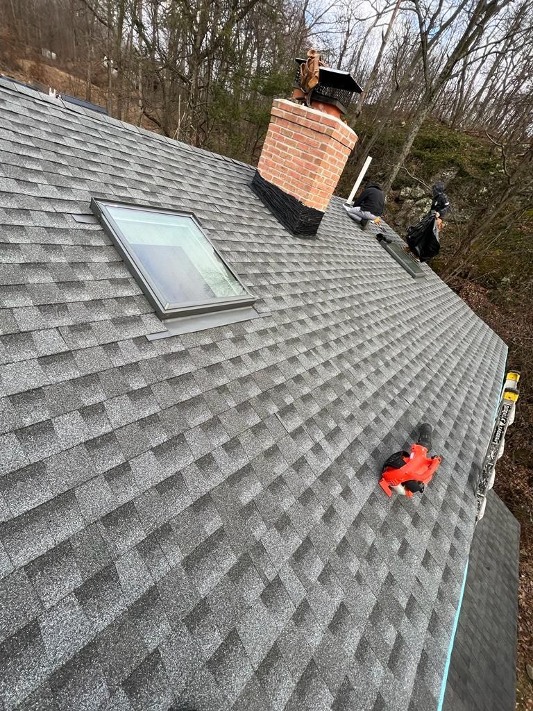 A roof with a skylight and a chimney on it.