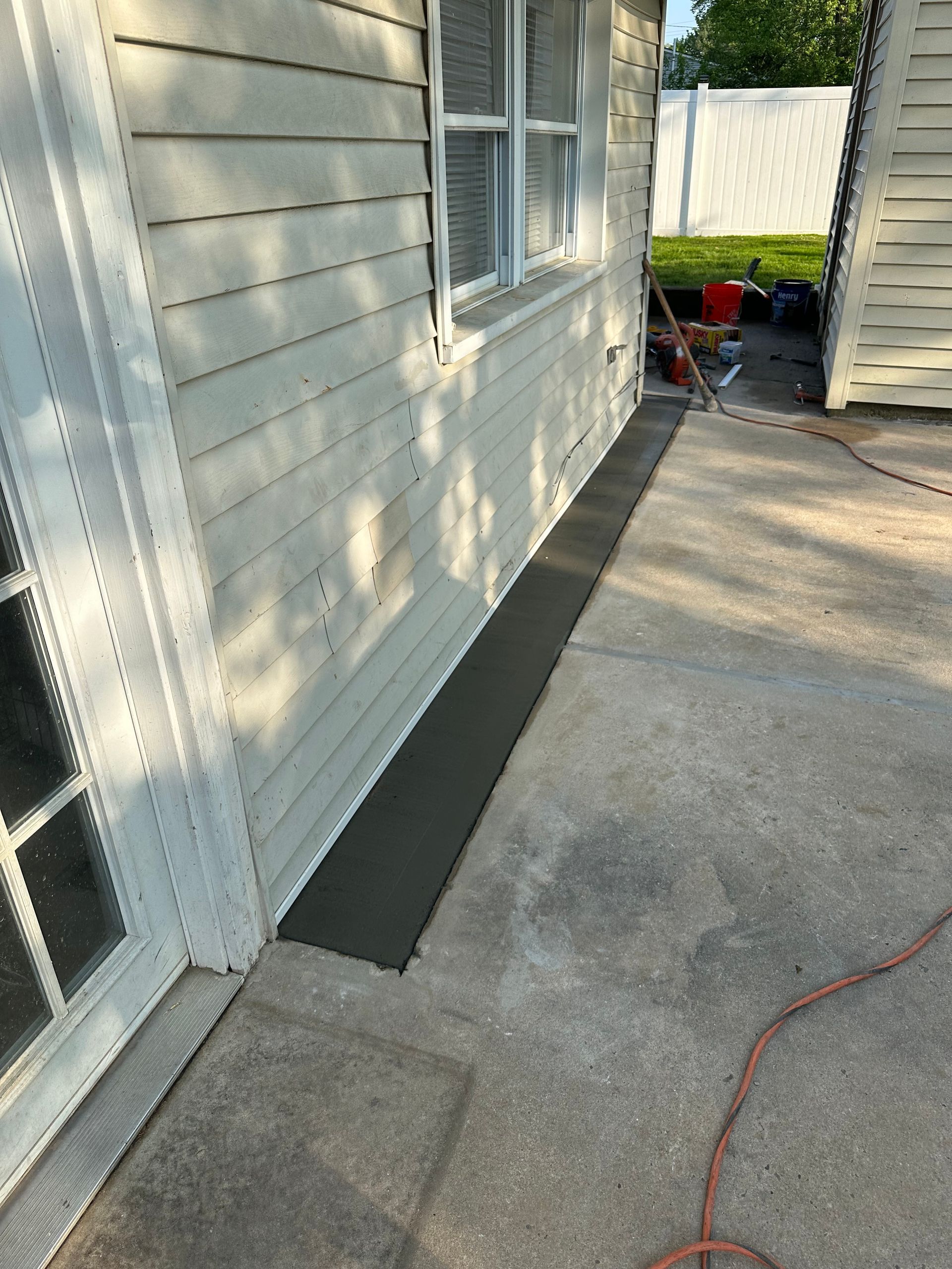 A white house with a concrete patio in front of it.