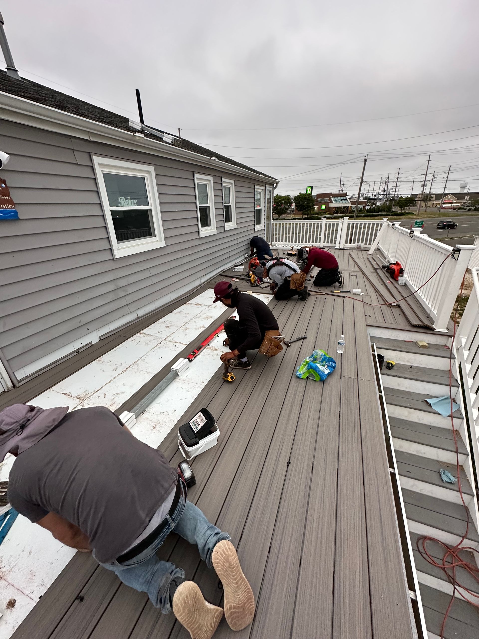 A group of people are working on the roof of a house.