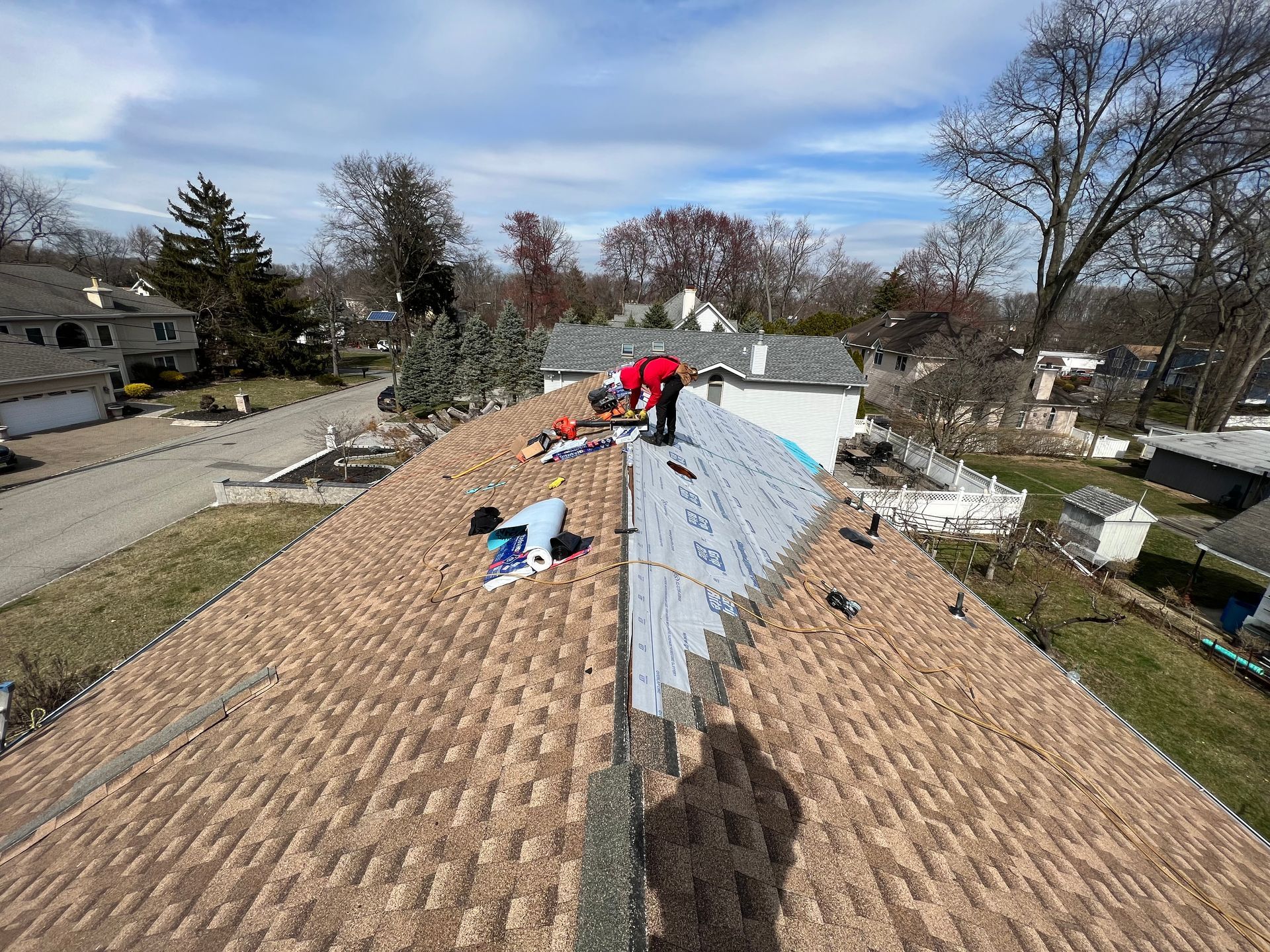A group of people are working on the roof of a house.