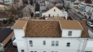 An aerial view of a white house with a brown roof.