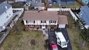 An aerial view of a house with a van parked in front of it.