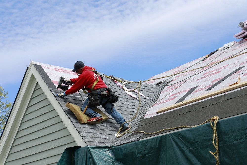 A man is working on the roof of a house.