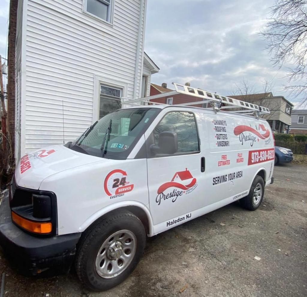 A white van is parked in front of a white house.
