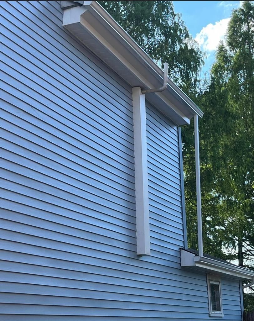 A white house with a gutter on the side of it