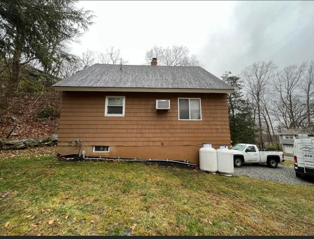 A brown house with a white truck parked in front of it.
