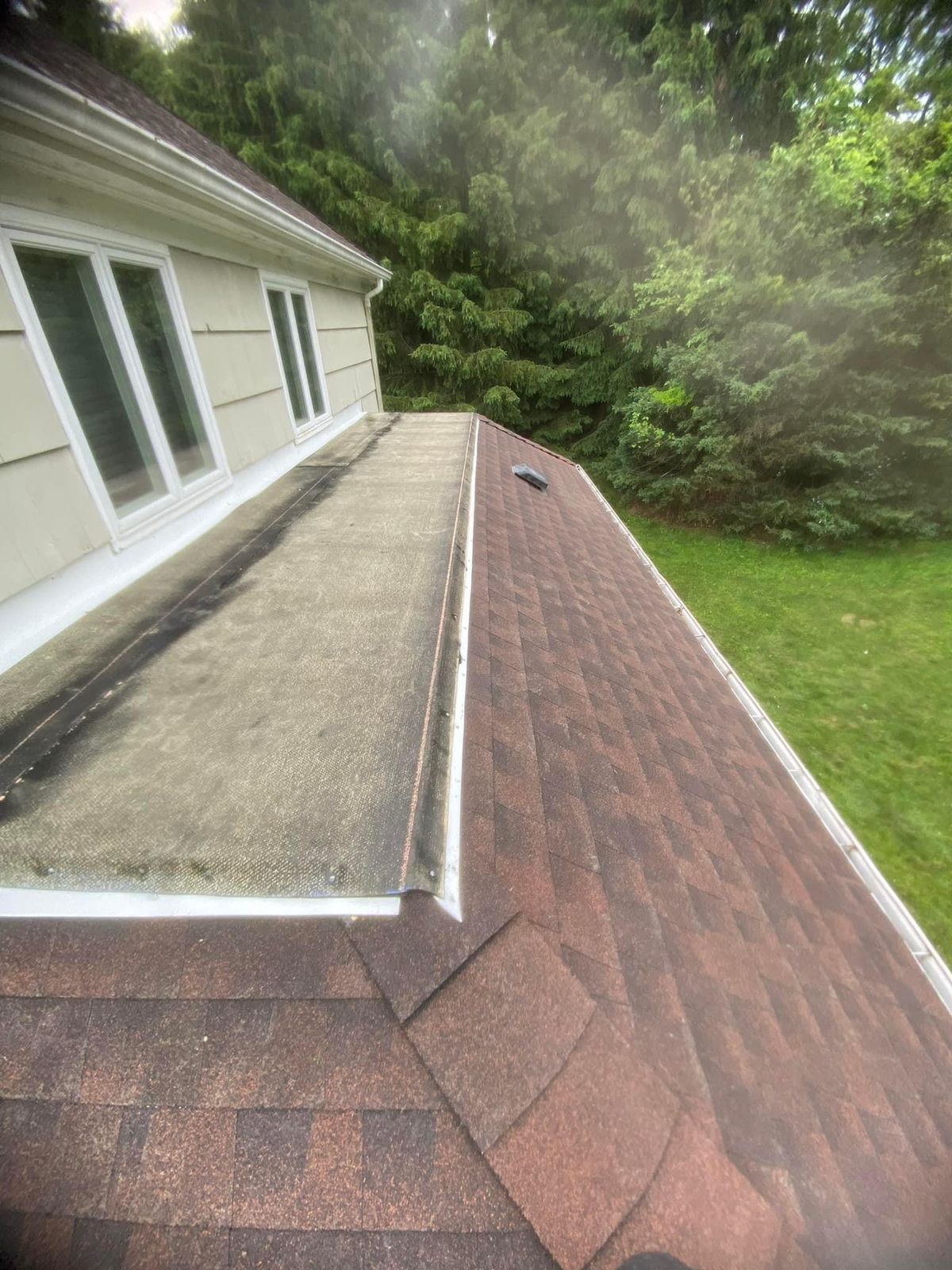 A house with a red roof and a gutter on the side of it.