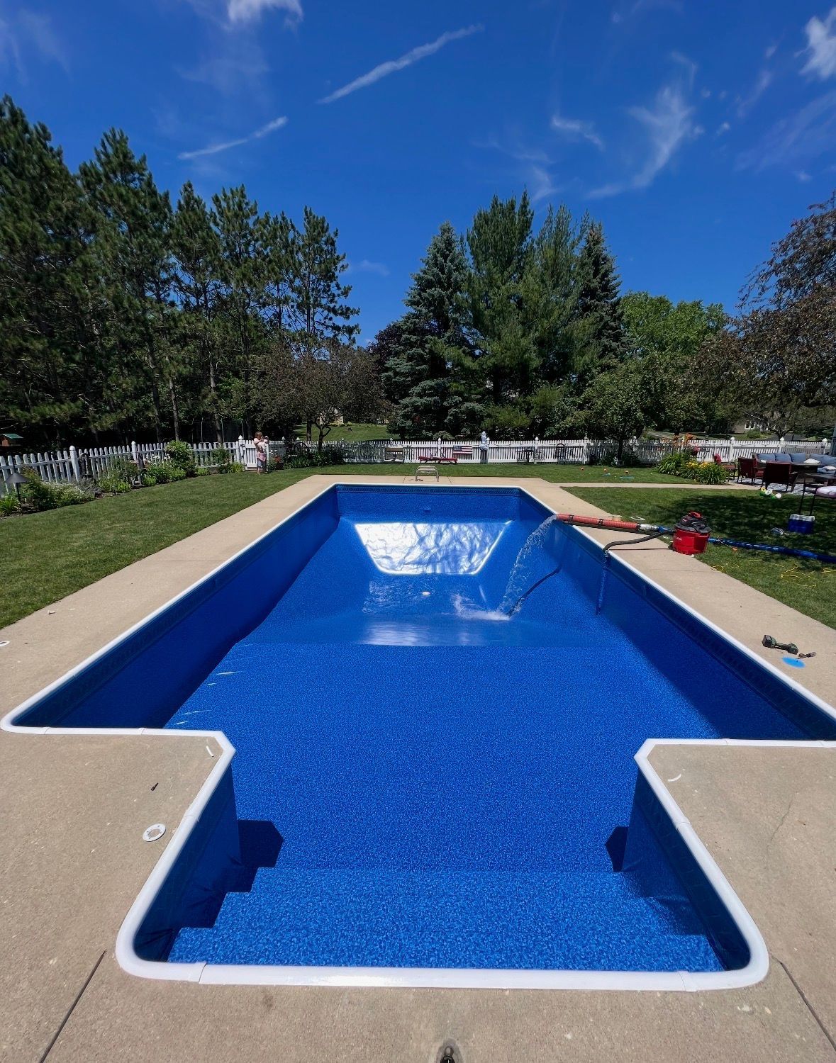 A large white house with a swimming pool in front of it