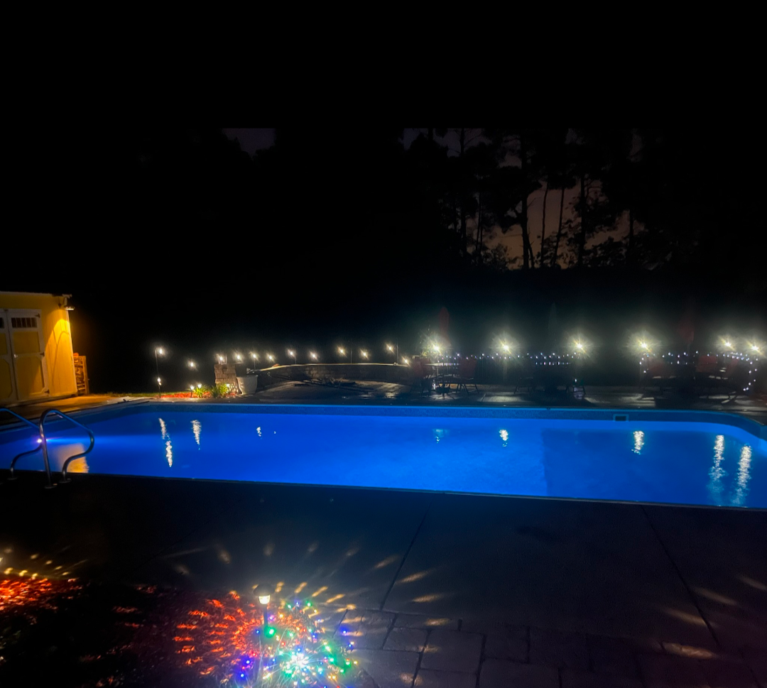 There is a large swimming pool in the backyard of a house.