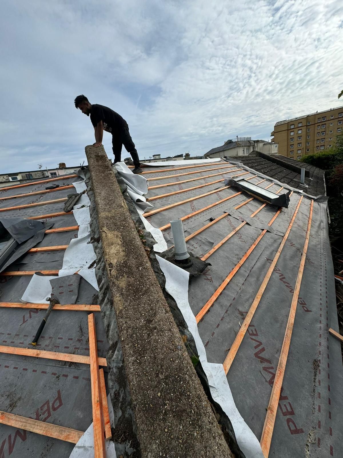 A man is working on the roof of a building.