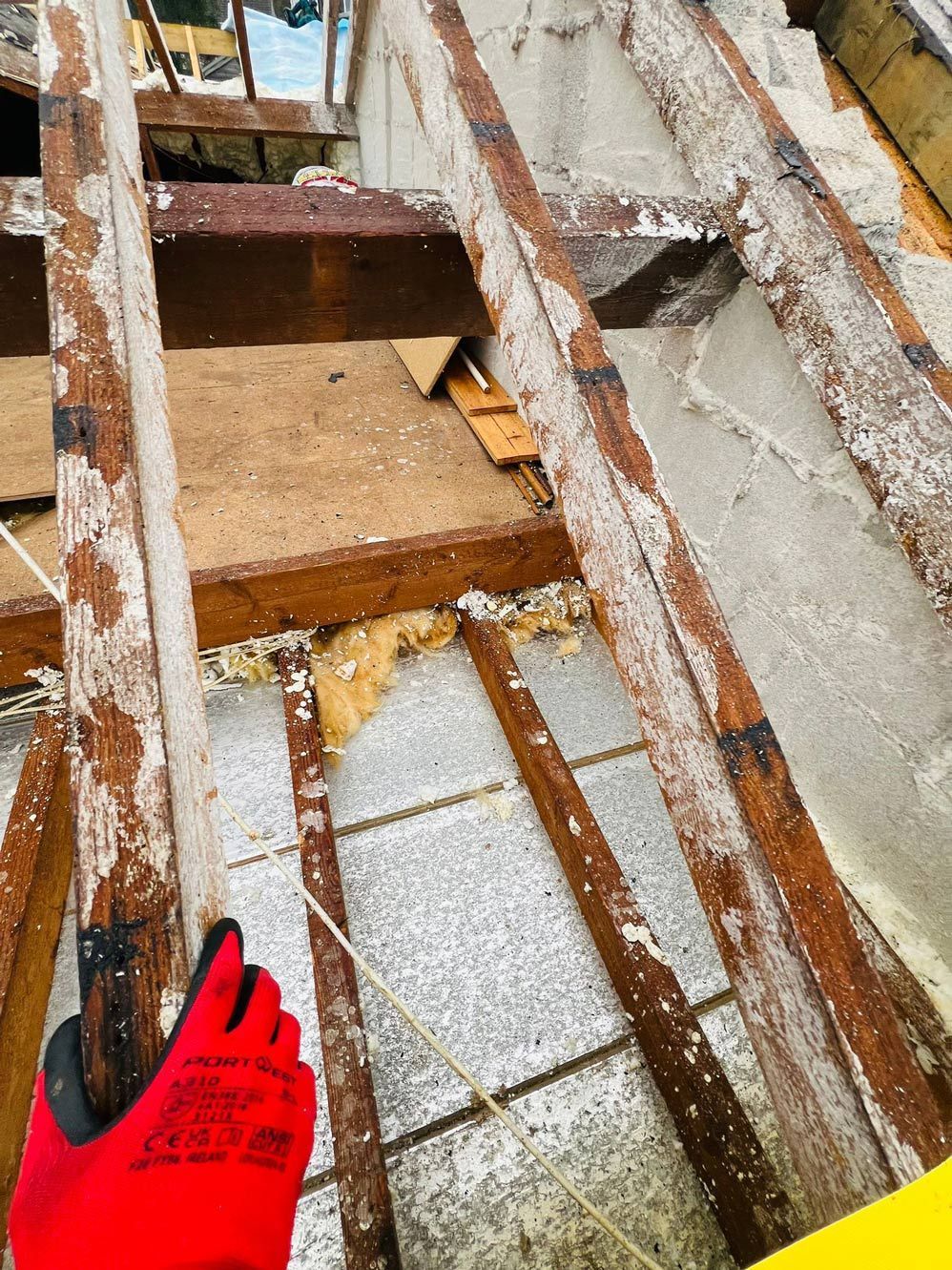 Roof dismantling by D&R Roofing, showing exposed wooden framework and debris.