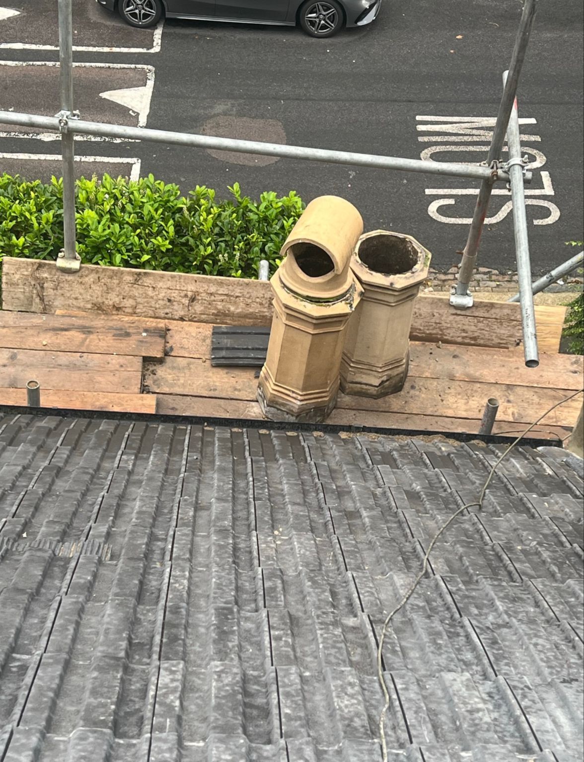 Two chimneys are sitting on the roof of a building.