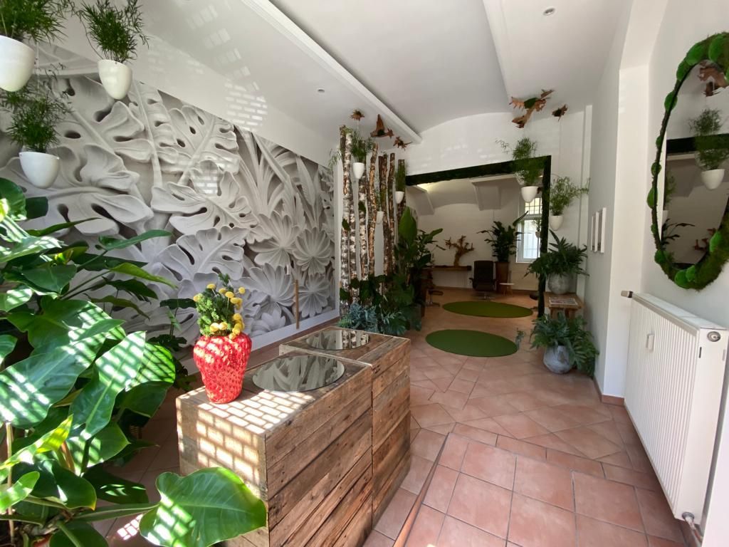 Ein Flur mit einem Holztisch und Pflanzen, die von der Decke hängen.