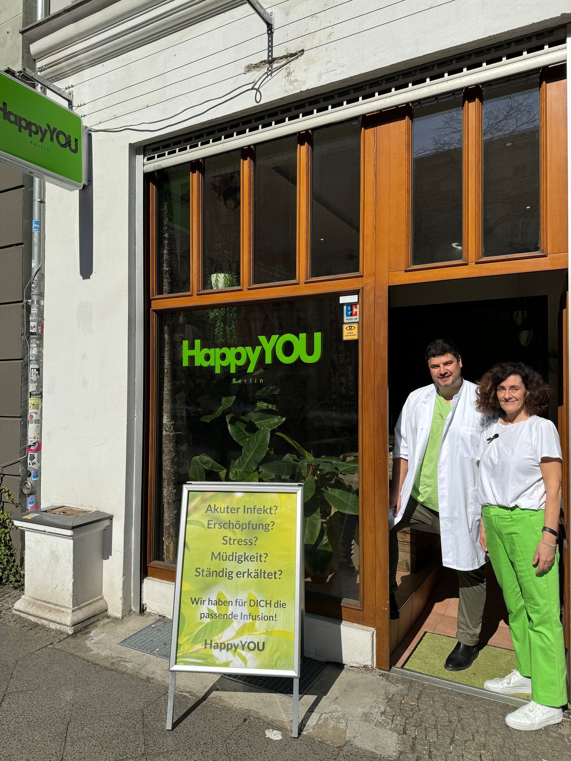 Ein Mann und eine Frau stehen vor einem Geschäft namens Happy You