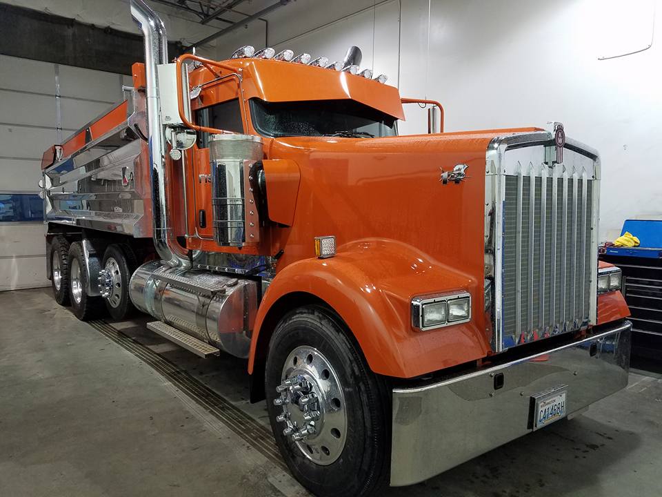 Orange dump truck parked inside a garage.