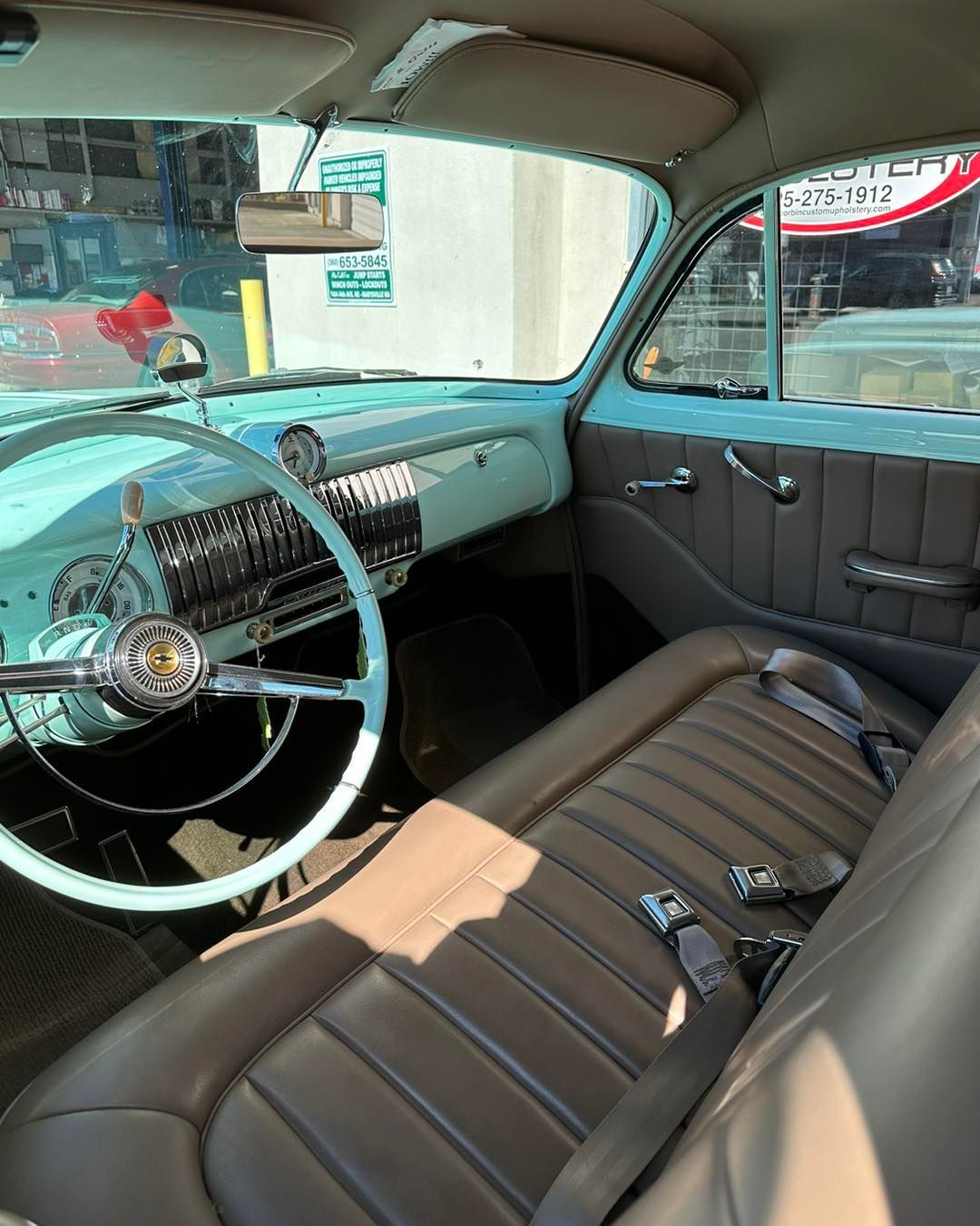 The inside of a car with a steering wheel and seats