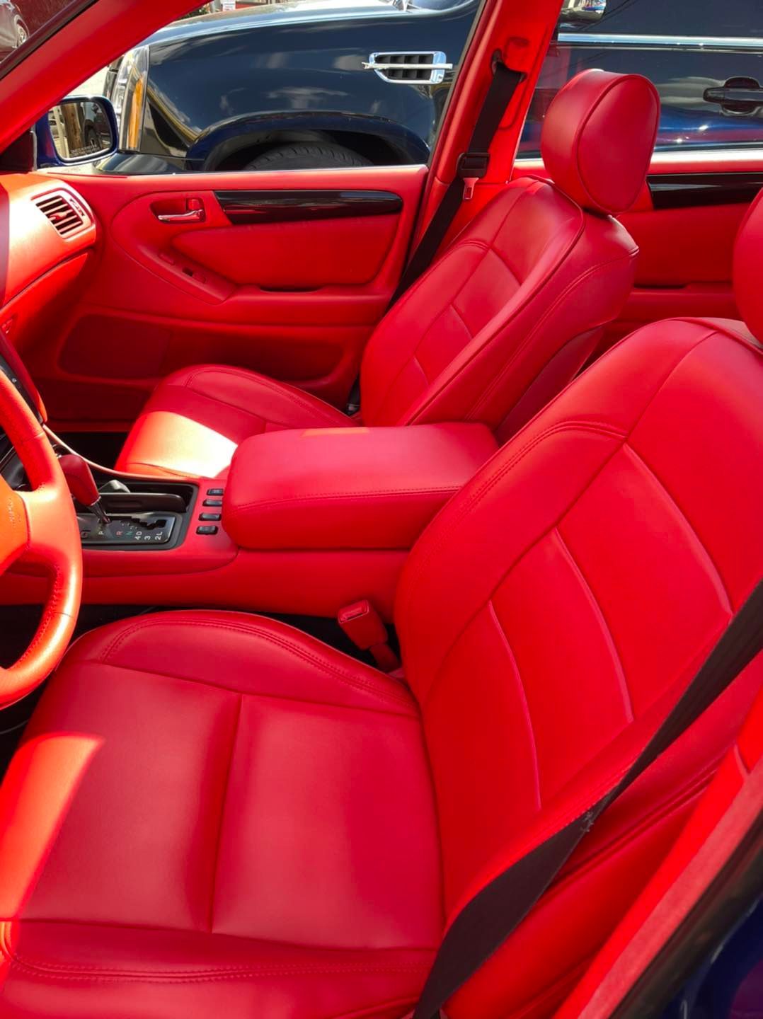 The inside of a car with red seats and a steering wheel