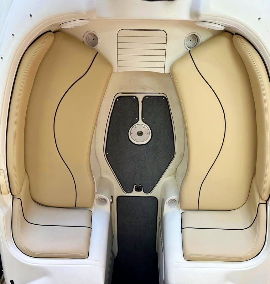 The inside of a boat with two tan seats