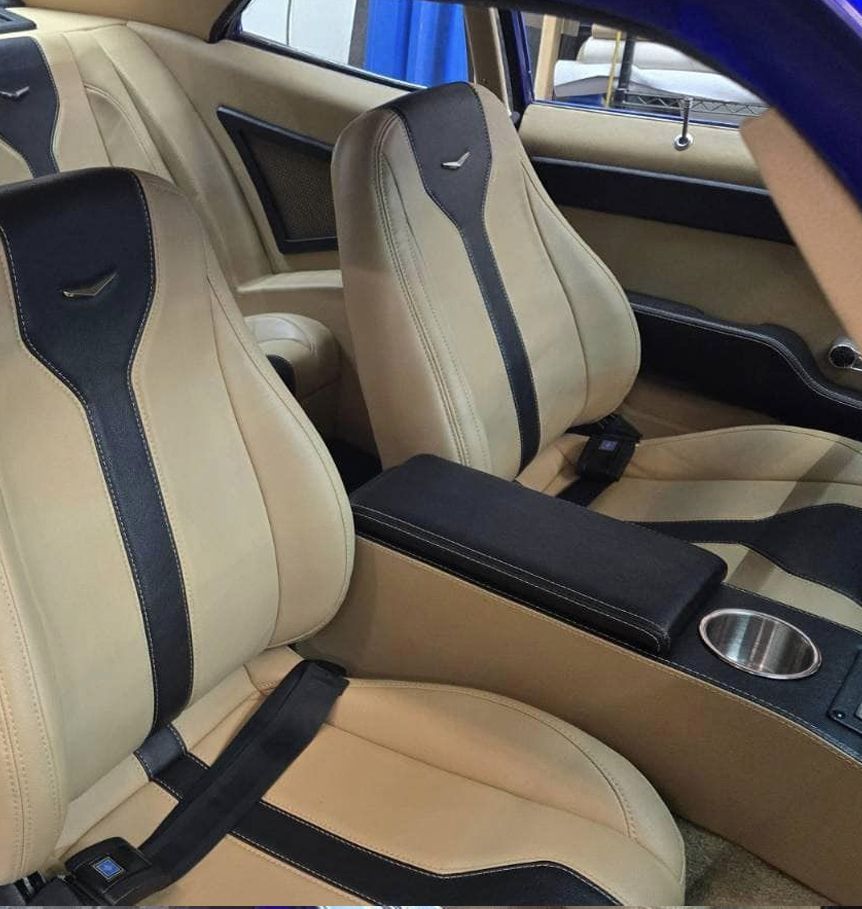 The inside of a car with tan and black seats
