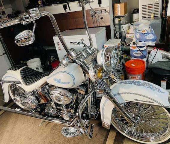 A white harley davidson motorcycle is parked in a garage.