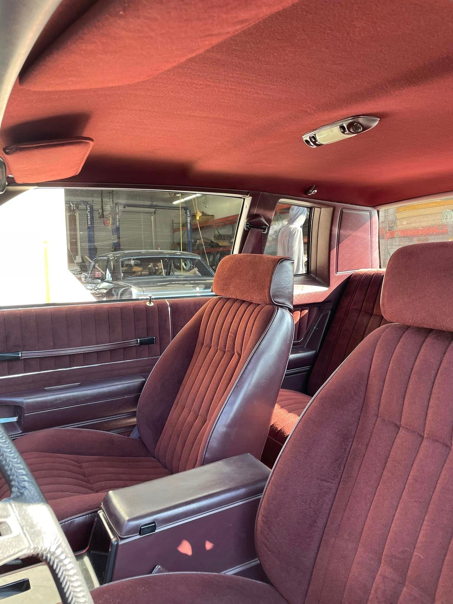 The inside of a car with red seats and a red ceiling.