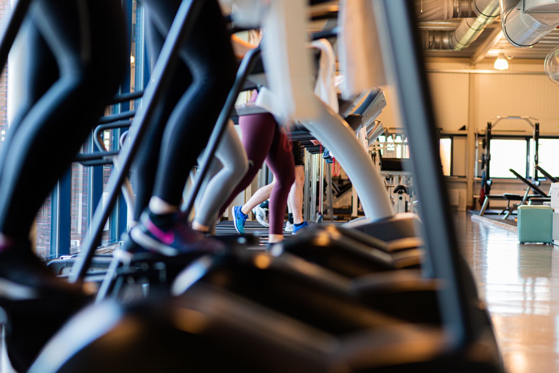 Een groep mensen fietst op crosstrainers in een sportschool.