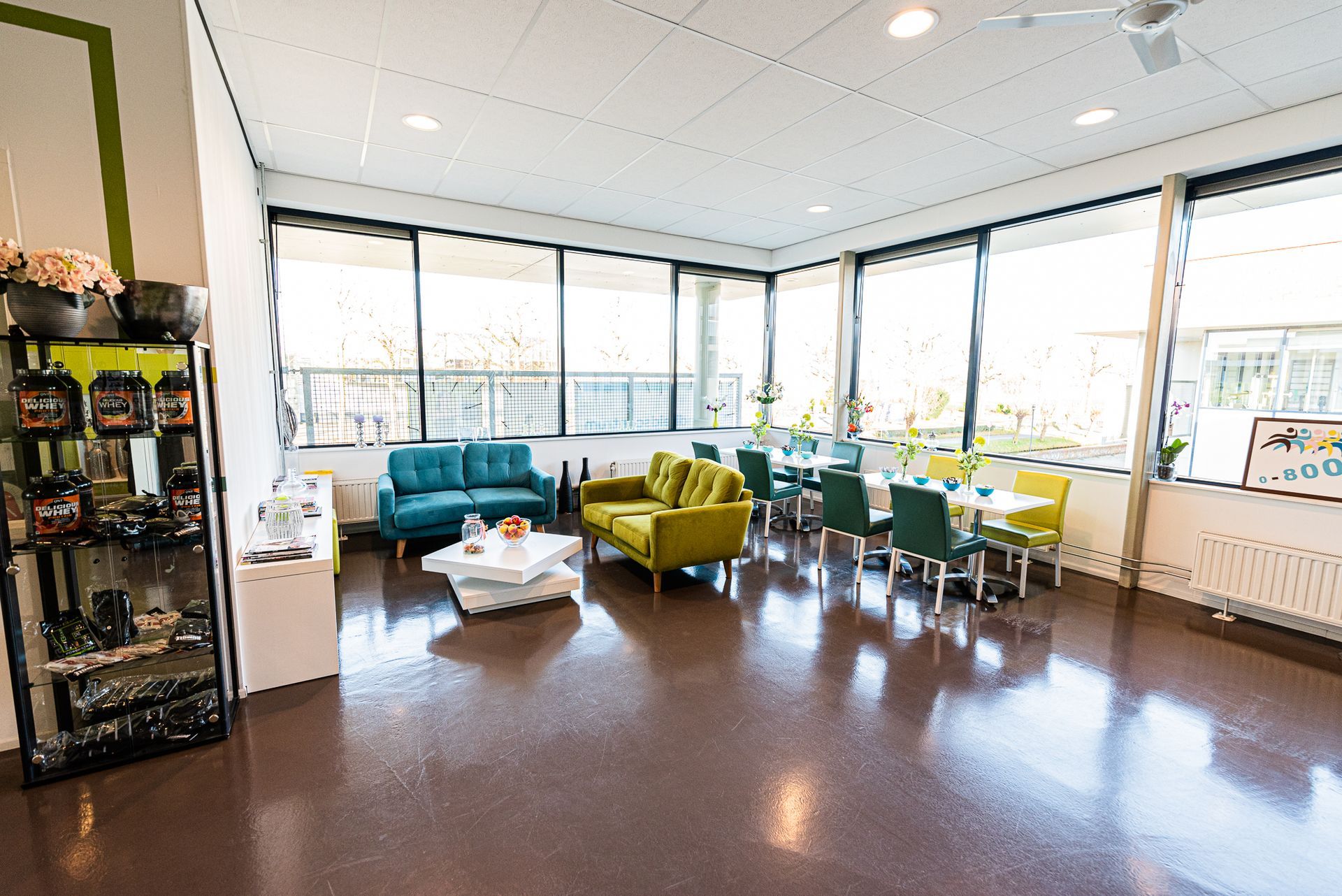 Een grote kamer met veel ramen en meubels.