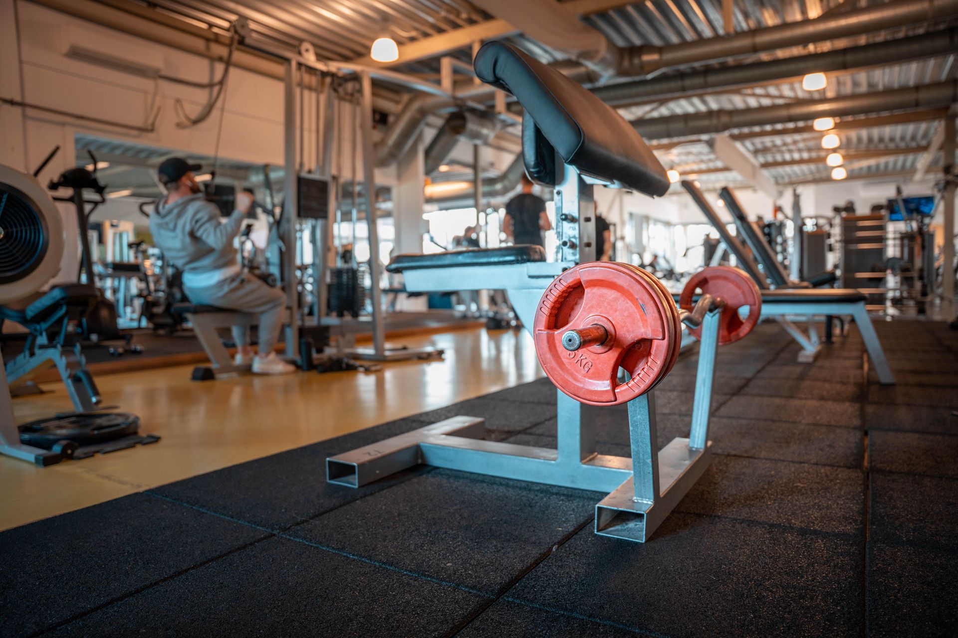 Een man zit op een bankje in een sportschool.