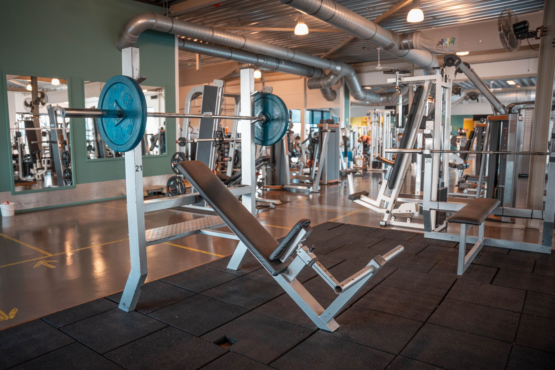 Er staat een bank met een halter erop in een gymzaal.