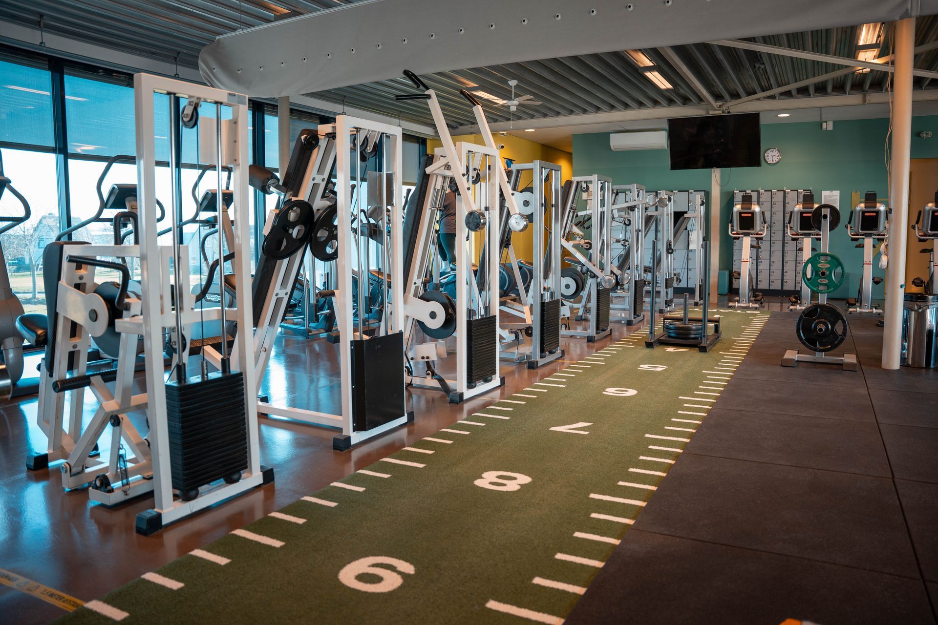 Een grote sportschool vol met fitnessapparatuur.
