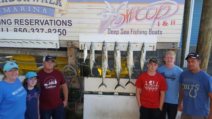 A group of people standing in front of a sign that says fishing reservations