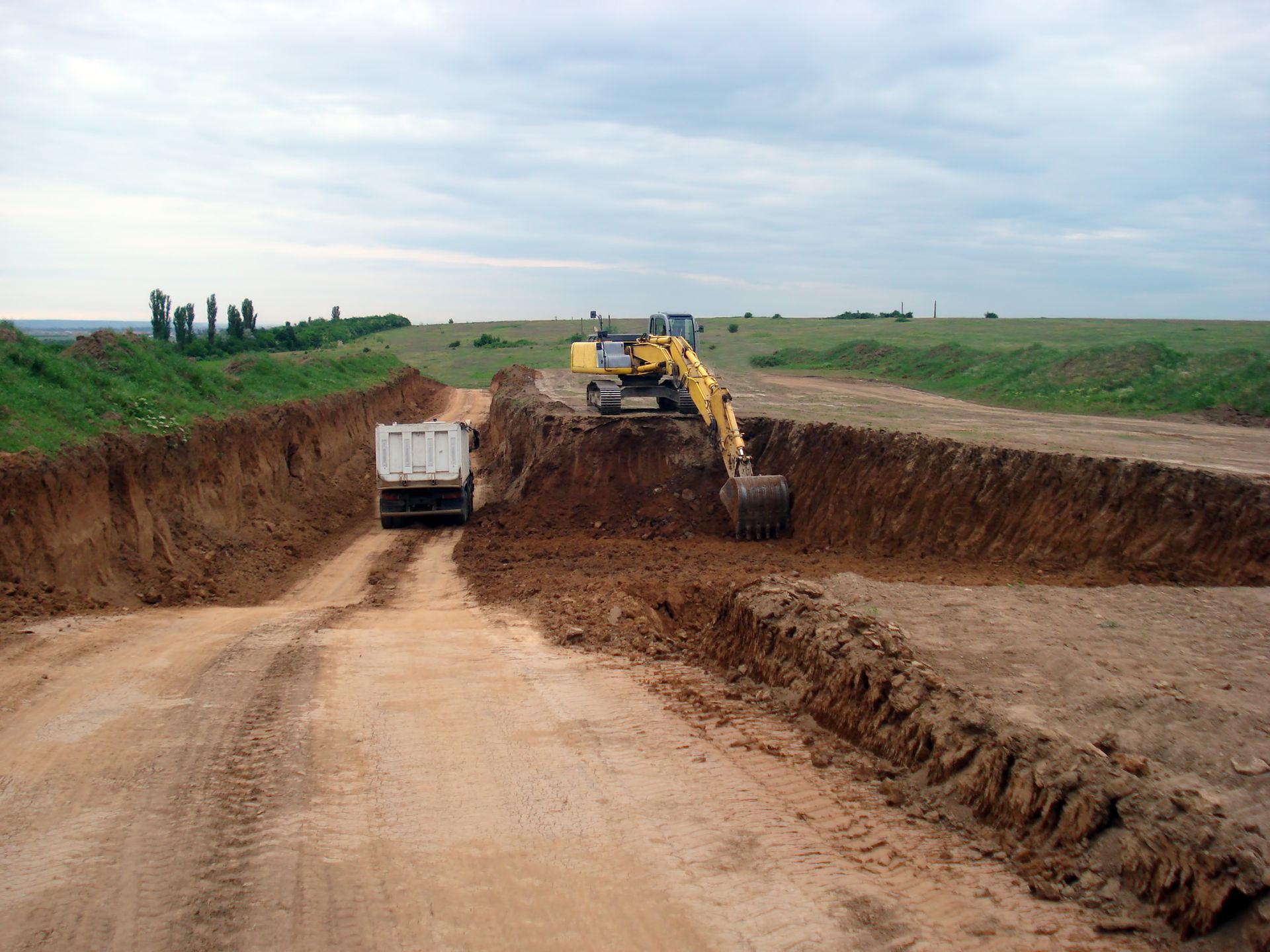 Excavator loading dirt into a dump truck on a construction site.