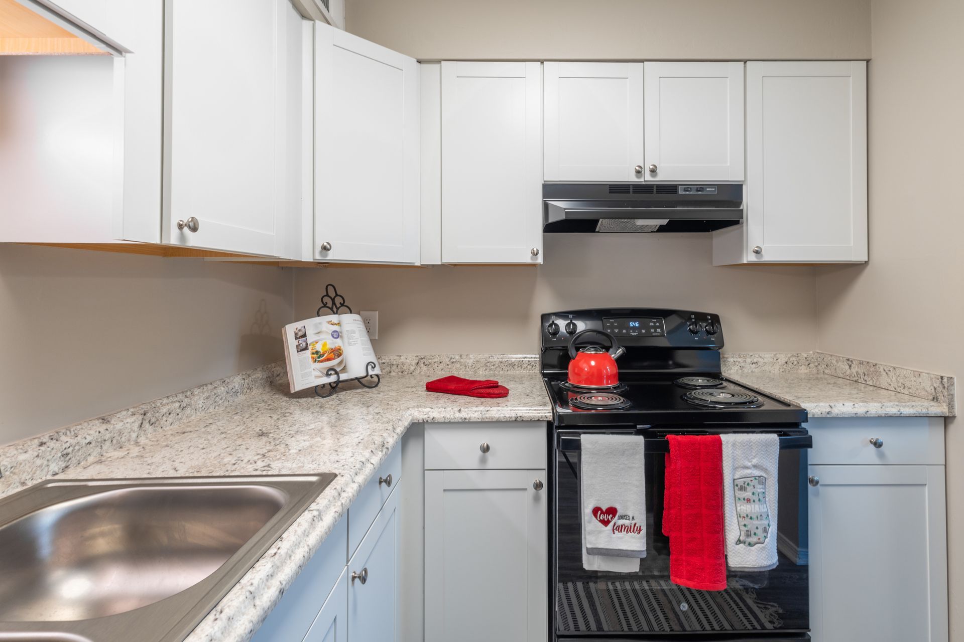 a kitchen with a stove , sink , and cabinets .