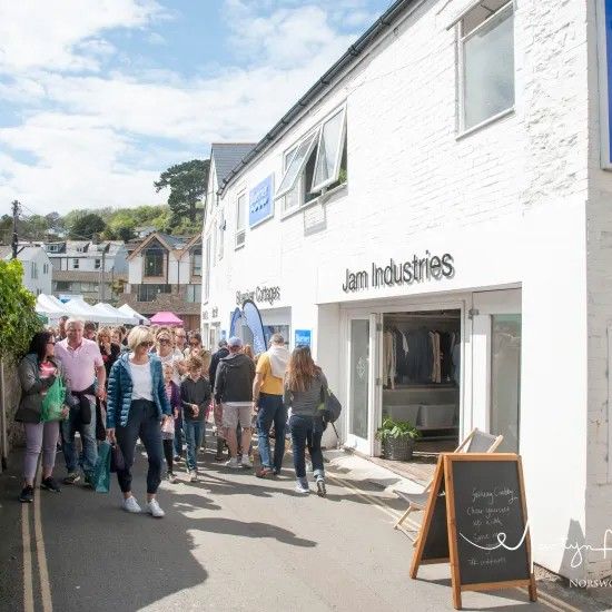 People walking along a street with shops; sunny day. 