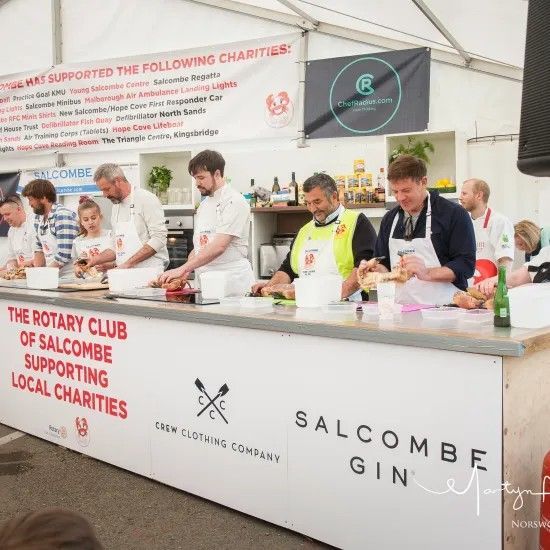 Chefs cooking at a Rotary Club event supporting local charities.