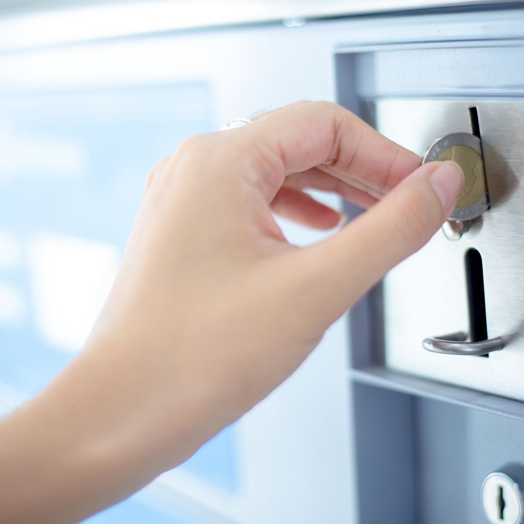 A person is putting a coin into a machine