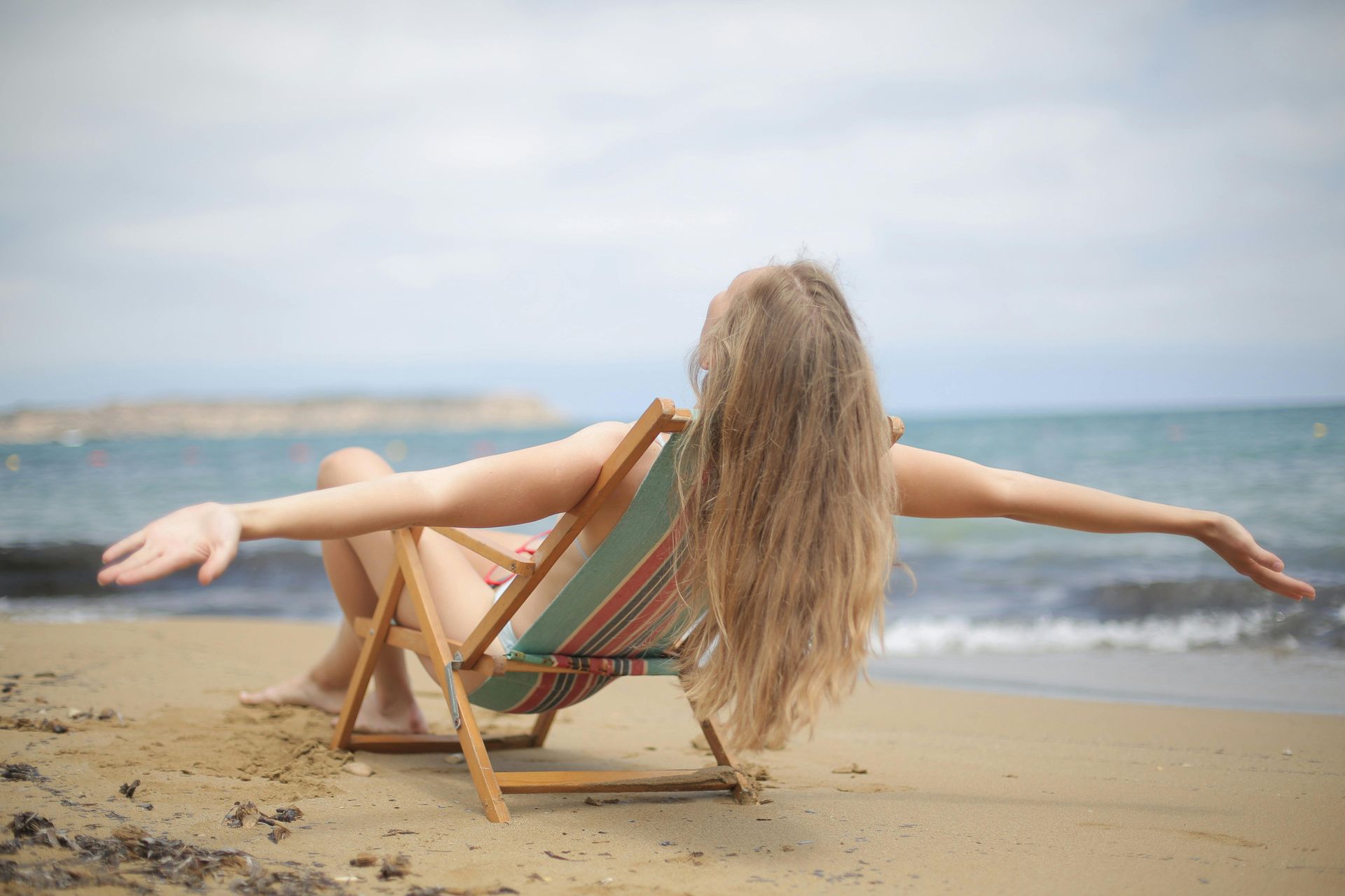 women at the beach, relaxed and arms open 